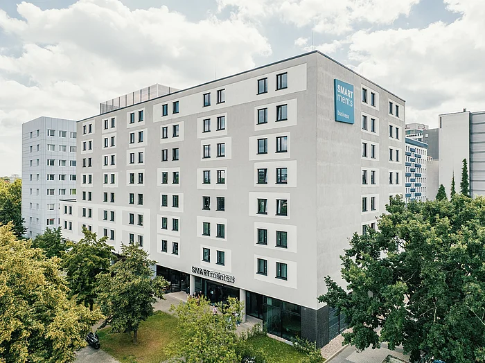 Modernes mehrstöckiges Gebäude mit Bäumen davor